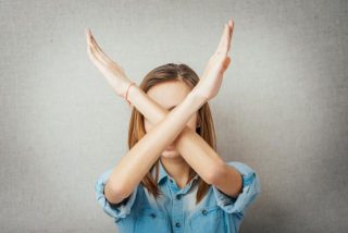 手で大きくバツを作っている女性